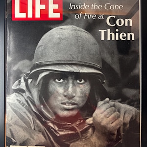 May include: Framed vintage LIFE magazine cover featuring a soldier in a helmet, with the headline "Inside the Cone of Fire at Con Thien." The LIFE logo is in a red box. The cover is dated October 27, 1967.