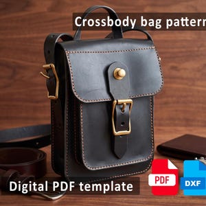 Puede incluir: Un bolso bandolera de cuero negro con asa superior, solapa frontal asegurada por una hebilla de latón y costuras visibles. La imagen incluye el texto Crossbody bag pattern y Digital PDF template, junto con iconos de archivo PDF rojo y DXF azul.