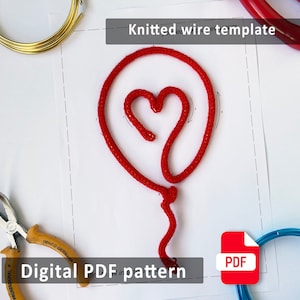May include: A red knitted wire heart-shaped balloon on a white surface, with a digital PDF pattern. The image includes tools and wire spools in gold and blue. Text on the image reads "Knitted wire template" and "Digital PDF pattern".