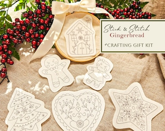 May include: A crafting gift kit with the text "Stick & Stitch Gingerbread." The kit includes a wooden embroidery hoop with a gingerbread house design, plus gingerbread man, woman, tree, heart, and star shapes for stitching.