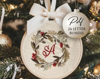May include: Embroidered Christmas ornament with a wreath design and the letter "A" in red. The ornament is attached to a cream-colored ribbon and bow. A separate white ornament reads "Pdf 26 Letter Bundle".