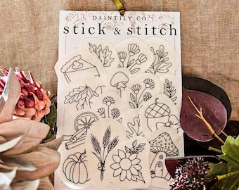 May include: A Daintily Co. stick and stitch embroidery stabilizer sheet featuring various black line art designs including a slice of pie, leaves, flowers, a mushroom, an acorn, a pumpkin, wheat stalks, a sunflower, and a mushroom house.