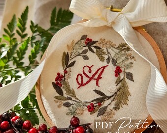 May include: Embroidered wreath with red berries and the letter "A" in a wooden hoop, tied with a cream ribbon. The wreath features green and brown leaves. Text on the image reads "PDF Pattern Full Alphabet".
