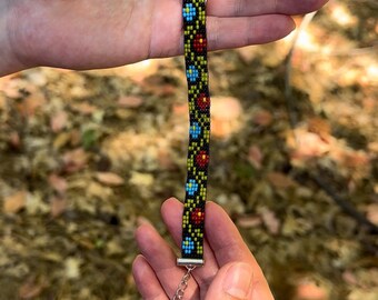 Pulsera de cuentas florales, flores rojas y azules sobre fondo negro, pulsera ajustable hecha a mano con cierre de plata