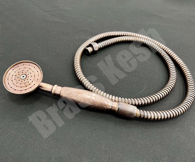 Pu&ograve; includere: Soffione doccia color rame con flessibile abbinato. Il soffione ha una piastra di spruzzo circolare con pi&ugrave; fori. L'impugnatura presenta un design ornato e inciso. Il tubo &egrave; in stile metallico ondulato.