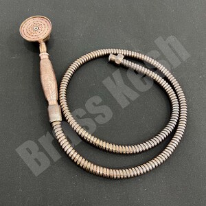 Pu&ograve; includere: Soffione doccia color rame con flessibile abbinato. Il soffione ha una piastra di spruzzo rotonda e un manico decorativo con un design inciso. Il tubo flessibile &egrave; a spirale e collegato al soffione.