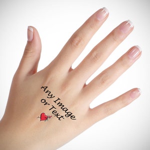 Puede incluir: Una mano con un tatuaje temporal de un corazón rojo con una flecha que lo atraviesa. El tatuaje también incluye el texto "Any Image or Text".