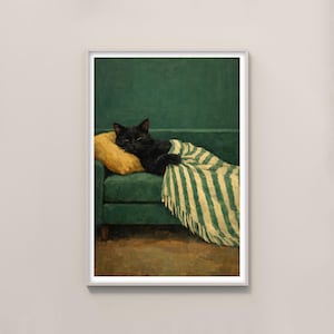 May include: A framed print of a black cat lounging on a green sofa. The cat rests on a yellow pillow and is covered with a green and white striped blanket. The background is a solid green wall.