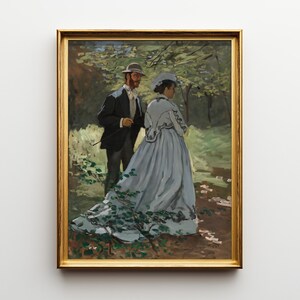 May include: A framed painting depicts a man and woman in a forest setting. The woman wears a long, light blue dress with floral accents. The man is in a dark suit and hat. The artwork is in a gold frame.