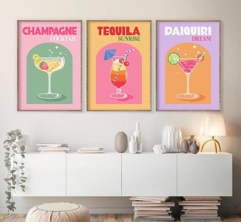 May include: Three colorful prints of cocktails with the names "Champagne Cocktail", "Tequila Sunrise", and "Daiquiri Dream" above each image.