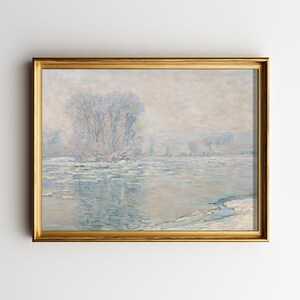 May include: A framed landscape painting with a gold-colored frame. The artwork depicts a winter scene with a river and snow-covered banks. The color palette is dominated by cool blues, whites, and grays, creating a serene and atmospheric view.