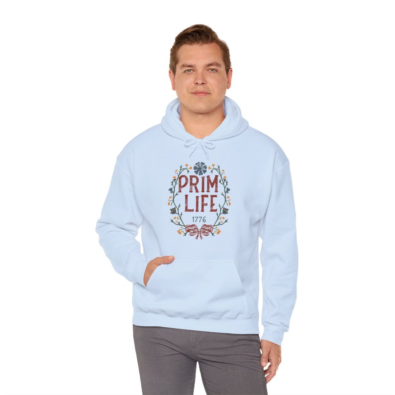 May include: Light blue hooded sweatshirt with a floral wreath design and the text "Prim Life 1776" in red.