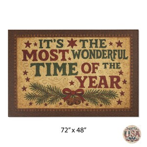 May include: Rectangular doormat with the text "IT'S THE MOST WONDERFUL TIME OF THE YEAR" in red and green. The mat has a brown border and measures 183cm x 122cm. Decorative elements include stars, bells, and pine branches.