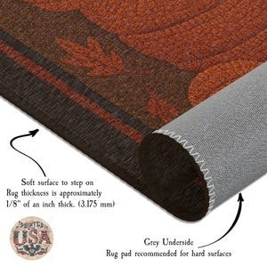 May include: A rolled-up brown and orange rug with a leaf design. The rug has a soft surface and is approximately 1/8 inch thick. The underside is gray. The rug is recommended for hard surfaces.