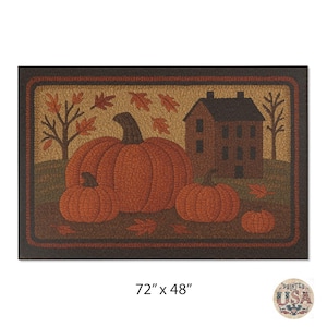 May include: Rectangular doormat featuring a fall harvest scene. The mat displays a large orange pumpkin with smaller pumpkins, a house, and autumn leaves. The mat measures 72 inches by 48 inches.