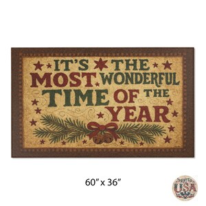 May include: Rectangular doormat with a brown border and a tan center. The text "IT'S THE MOST WONDERFUL TIME OF THE YEAR" is in red and green. The mat is 152cm x 91cm and features stars, bells, and pine branches.