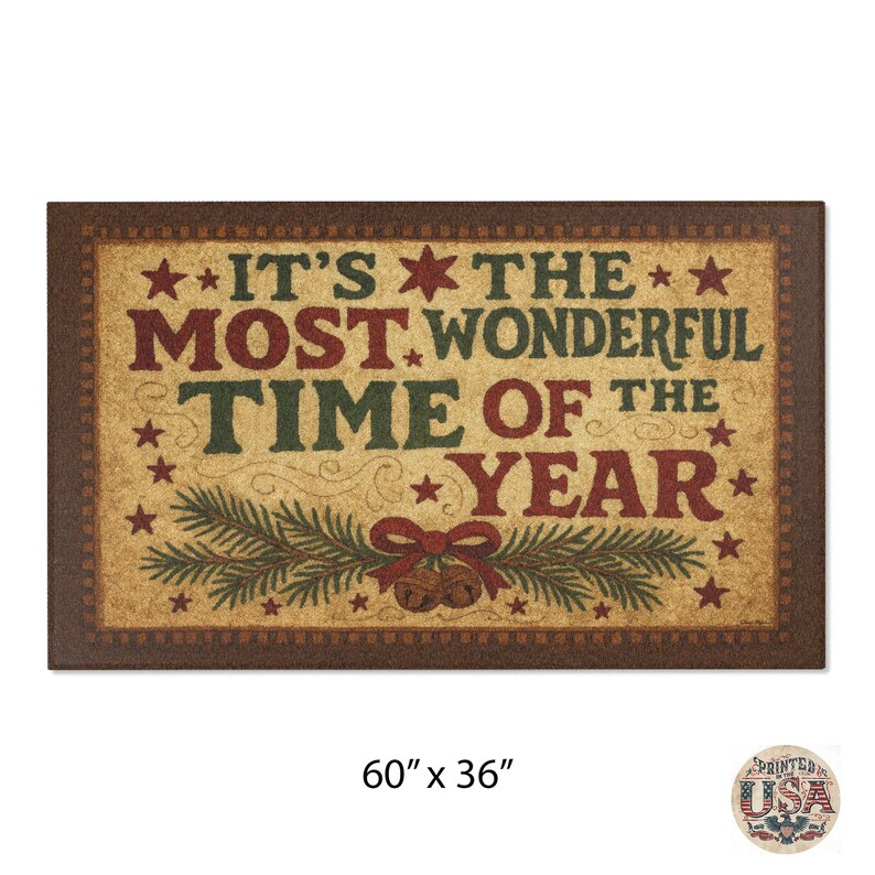 May include: Rectangular doormat with a brown border and a tan center. The text "IT'S THE MOST WONDERFUL TIME OF THE YEAR" is in red and green. The mat is 152cm x 91cm and features stars, bells, and pine branches.