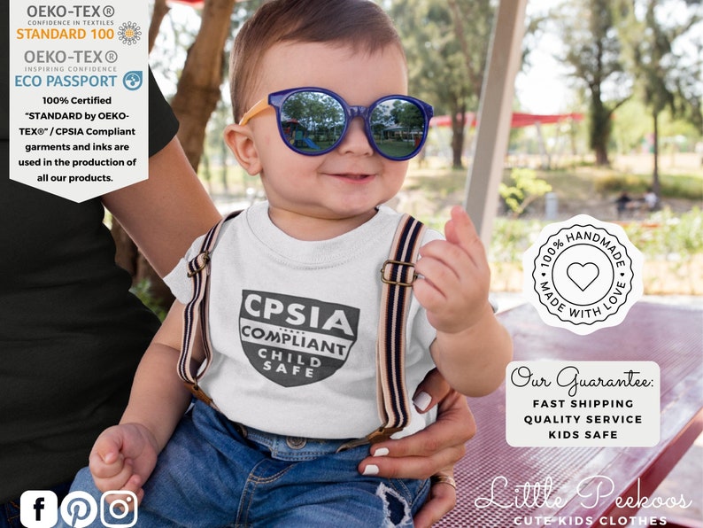 K&ouml;nnte beinhalten: Ein l&auml;chelndes Baby mit blauer Sonnenbrille und einem wei&szlig;en T-Shirt mit dem Text "CPSIA COMPLIANT CHILD SAFE". Das Baby tr&auml;gt auch Hosentr&auml;ger. Das Bild enth&auml;lt Text &uuml;ber die OEKO-TEX-Zertifizierung und handwerkliche Qualit&auml;t.
