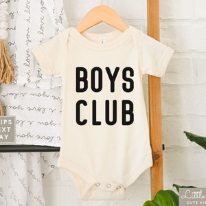 May include: A white baby onesie with black text that reads "BOYS CLUB".