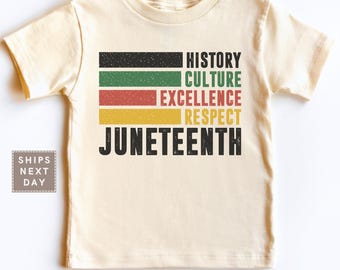 May include: A cream-colored t-shirt featuring the words "HISTORY CULTURE EXCELLENCE RESPECT JUNETEENTH" in a colorful, stacked design. The shirt has a classic crew neck and short sleeves. The text is in black, red, green, and yellow.