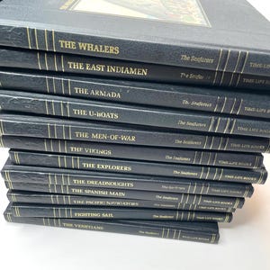 Puede incluir: Una pila de libros de la serie "The Seafarers" de Time-Life Books. Los libros tienen cubiertas azul oscuro con letras doradas. Los t&iacute;tulos incluyen "The Whalers", "The East Indiamen", "The Armada" y "The U-Boats".