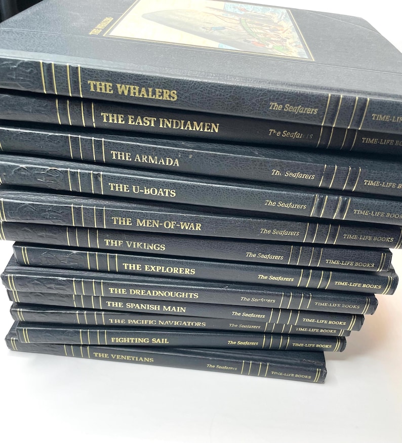 Puede incluir: Una pila de libros de la serie "The Seafarers" de Time-Life Books. Los libros tienen cubiertas azul oscuro con letras doradas. Los t&iacute;tulos incluyen "The Whalers", "The East Indiamen", "The Armada" y "The U-Boats".