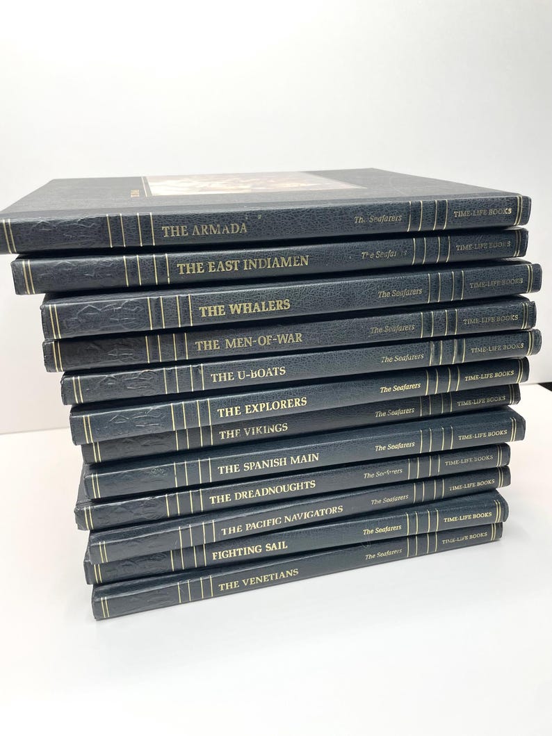 Puede incluir: Una pila de libros de tapa dura azul oscuro de la serie Time-Life Books, "The Seafarers". Los t&iacute;tulos incluyen "The Armada", "The East Indiamen" y "The Whalers". Los libros tienen letras doradas y un aspecto texturizado.