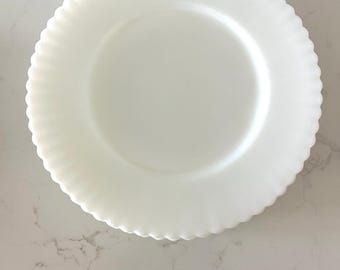 May include: A white, round, ceramic plate with a scalloped edge.