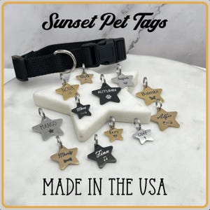 May include: A collection of gold, silver, and black star-shaped pet tags with various names engraved on them. The tags are arranged on a white surface with a black collar in the background. The text "Sunset Pet Tags" and "MADE IN THE USA" are visible in the image.