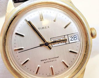 Reloj Timex automático para hombre con calendario, día y fecha, chapado en oro y acero inoxidable, estilo vintage.
