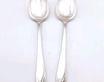 May include: Two silver spoons with floral designs on the handles. The spoons have a polished finish and are in good condition.