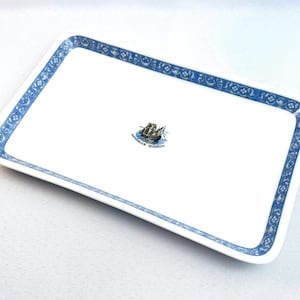 May include: A white rectangular serving tray with a blue and white floral border. The center of the tray features a blue and white illustration of a ship with the text "Hendrick Hudson" underneath.