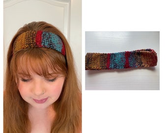May include: A crocheted headband with brown, red, teal, and blue stripes. The headband is shown on a person's head and laid flat.