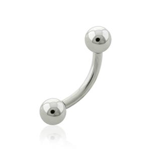 Pode incluir: Uma joia corporal de barra curva feita de metal polido em tom prateado. O item apresenta uma haste arqueada lisa com uma conta esférica fixada em cada extremidade, criando uma estética metálica limpa, reflexiva e minimalista.