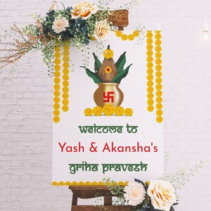 May include: A white sign with a gold pot and green leaves, decorated with yellow flowers. The sign reads "Welcome to Yash & Akansha's Griha Pravesh".
