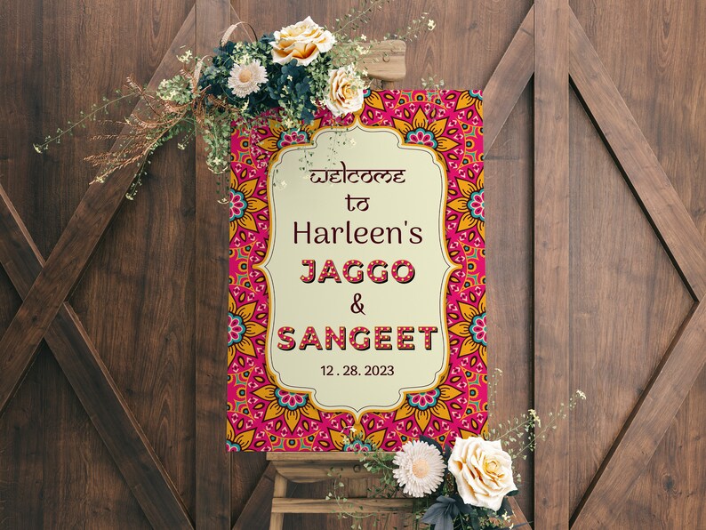 Pu&ograve; includere: Un cartello di benvenuto per un evento Jaggo & Sangeet con un design floreale rosa e giallo. Il cartello recita "Benvenuti a Harleen's Jaggo & Sangeet 12.28.2023".