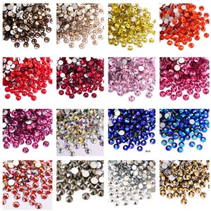 May include: Assortment of 12 colours of round, faceted rhinestones with silver backing. The colours are: black, clear, gold, red, ruby, pink, fuchsia, crystal, blue, sapphire, silver, and champagne.