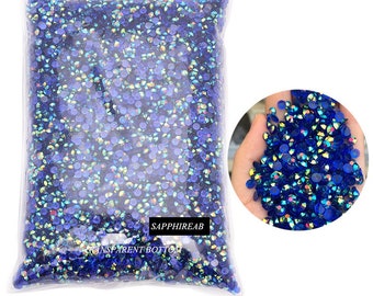 May include: A large bag of blue iridescent rhinestones. The bag is clear plastic and has the text "SAPPHIREAB" and "TRANSPARENT BOTTOM" printed on it. A close-up image shows the rhinestones in a hand.