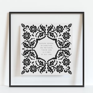 Könnte beinhalten: Gerahmtes Schwarz-Weiß-Kreuzstich-Kunstwerk. Das Design zeigt einen floralen Rahmen, der einen zentralen Text umgibt: „Jemanden auf allem blockieren und so tun, als ob er tot wäre, ist eine Form der Selbstfürsorge“.