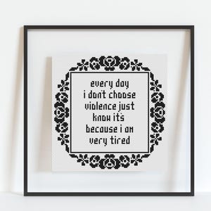 Op de afbeelding: Zwart-witte kruissteek borduurwerk met een bloemmotief en de tekst "every day I don't choose violence just know it's because I am very tired".
