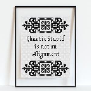 Puede incluir: Arte de punto de cruz enmarcado con el texto "Chaotic Stupid is not an Alignment". El texto negro está sobre un fondo blanco, enmarcado por bordes decorativos negros. El marco es negro.