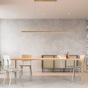 以下が含まれることがあります： 木製の四角いペンダントライトが、4脚の椅子のあるダイニングテーブルの上に吊り下げられています。テーブルは木製のライトブラウン仕上げです。椅子は金属製でライトグレー仕上げです。