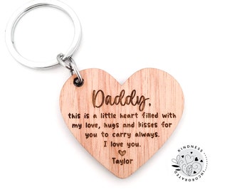 May include: Wooden heart-shaped keychain with the text "Daddy. This is a little heart filled with my love, hugs and kisses for you to carry always. I love you. ♡ Taylor" engraved on it. The keychain is attached to a silver key ring.