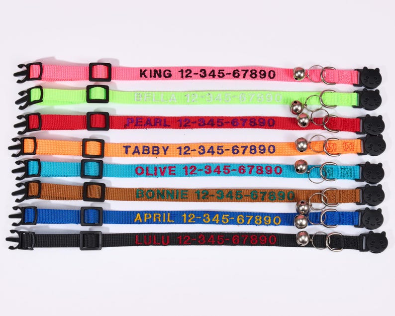 Pu&ograve; includere: Assortimento di collari per gatti colorati con campanelle e nomi e numeri di telefono ricamati personalizzati. I collari sono rosa, verde, rosso, arancione, blu, marrone, blu scuro e nero.