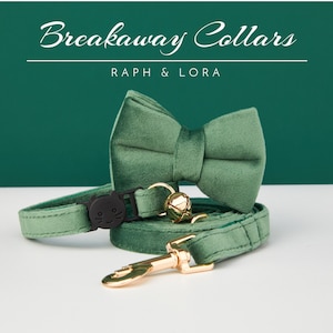 Könnte beinhalten: Ein grünes Samt-Sicherheitshalsband für Katzen mit passendem Fliege. Das Halsband hat eine schwarze Sicherheitsverschluss mit Katzenkopf-Design und eine goldene Glocke. Der Text "Breakaway Collars" und "Raph & Lora" ist auf grünem Hintergrund gedruckt.