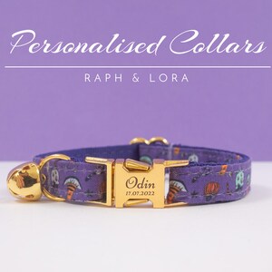 May include: Purple cat collar with a gold buckle and bell. The buckle has the name "Odin" and the date "17.07.2022" engraved on it. The collar has a spooky Halloween print with bats, ghosts, and pumpkins.