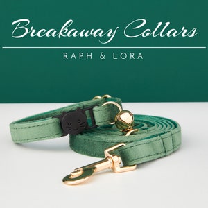May include: A green velvet breakaway cat collar with a black cat face charm and a gold bell. The collar is attached to a matching green velvet leash with a gold clasp.