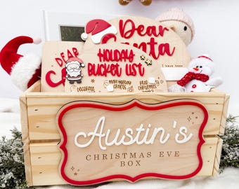 以下が含まれることがあります： 「Austin's Christmas Eve Box」と書かれた赤と白の看板が付いた木製のクリスマスイブボックス。ボックスにはサンタの帽子、雪だるま、そして「Dear Santa」と「Holidays Bucket List」と書かれた木製の看板が入っています。