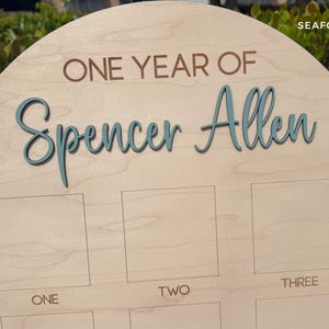 Arch birthday photo board.  Showing the 3D name in a seafoam color.