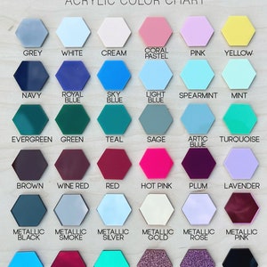 May include: An acrylic color chart titled the olive branch featuring thirty-six hexagonal swatches in various solid, metallic, and glitter finishes. Each swatch is labeled with its corresponding color name, including grey, blue, pink, and gold.